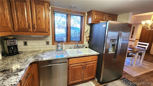 kitchen featuring appliances with stainless steel finishes, brown cabinets, and a sink