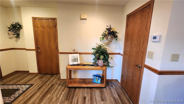 doorway to outside featuring baseboards and wood finished floors