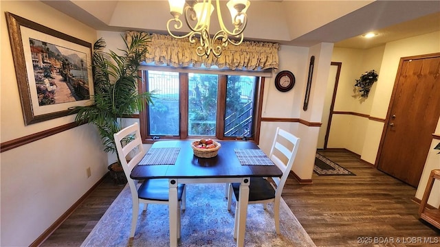 dining space with an inviting chandelier, baseboards, and wood finished floors