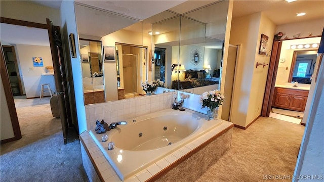 full bathroom with a jetted tub, baseboards, and vanity