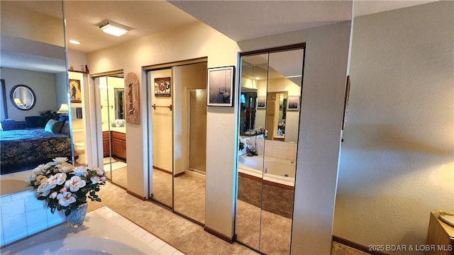 interior space with a shower, ensuite bathroom, vanity, baseboards, and a bath