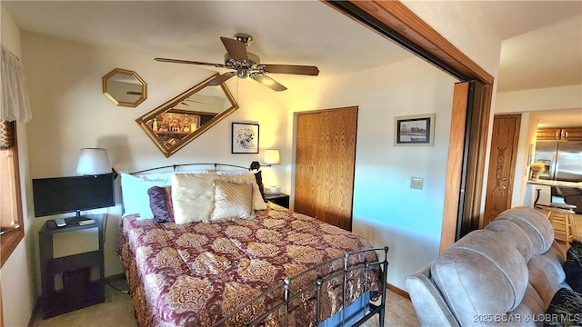 carpeted bedroom featuring a ceiling fan and stainless steel refrigerator with ice dispenser