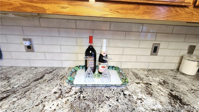 room details featuring backsplash and light stone countertops