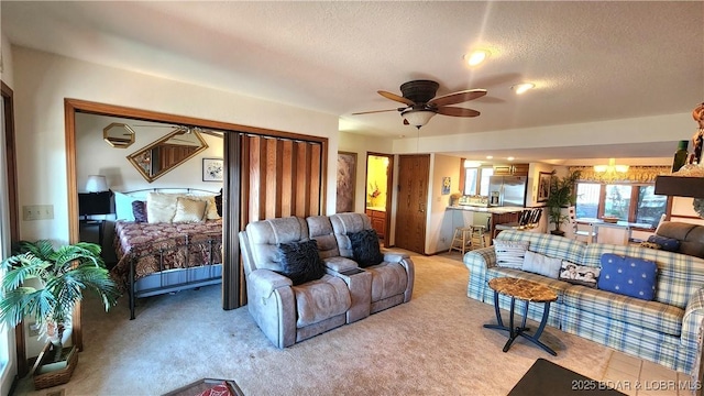 living area featuring a textured ceiling, ceiling fan with notable chandelier, and light carpet