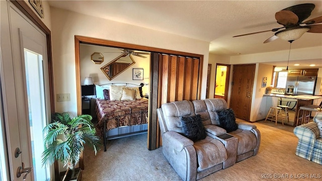 living room featuring a textured ceiling, a ceiling fan, and light colored carpet