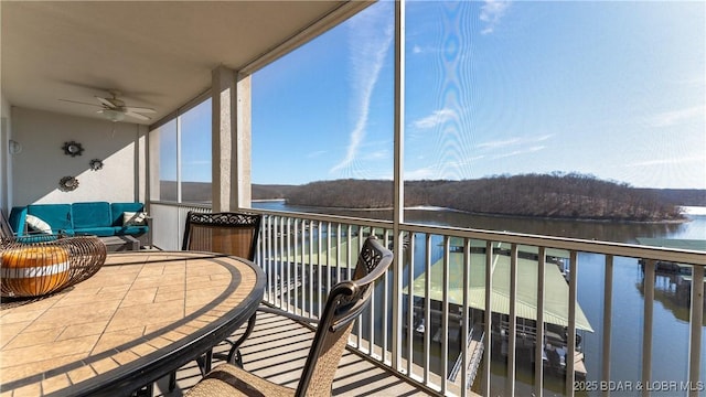 balcony with a water view, outdoor lounge area, and a ceiling fan