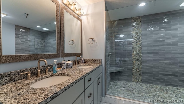 bathroom with double vanity, a sink, and a walk in shower