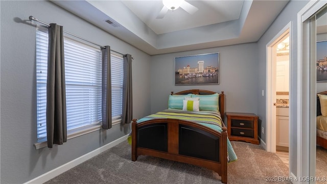 bedroom featuring carpet, a tray ceiling, visible vents, a ceiling fan, and baseboards