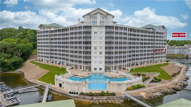 view of building exterior with a water view and a community pool