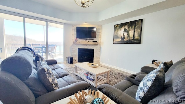 living area with a fireplace, baseboards, and wood finished floors