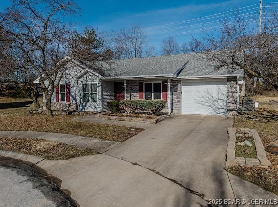 ranch-style house with concrete driveway, a shingled roof, an attached garage, and brick siding