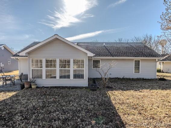 back of house featuring roof with shingles and a patio