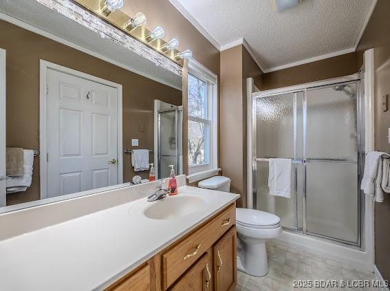 full bathroom with ornamental molding, a stall shower, a textured ceiling, and vanity