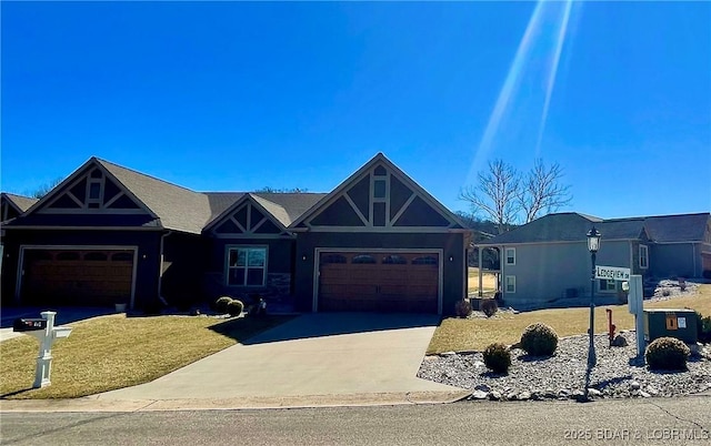 view of front of property featuring a garage, driveway, and a front lawn