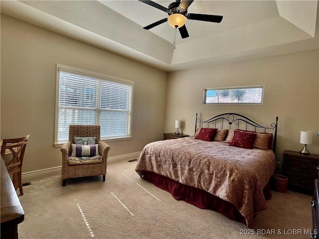 bedroom with a raised ceiling, carpet flooring, visible vents, and baseboards