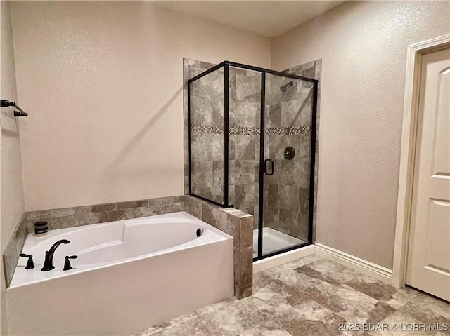 bathroom with a stall shower and a garden tub