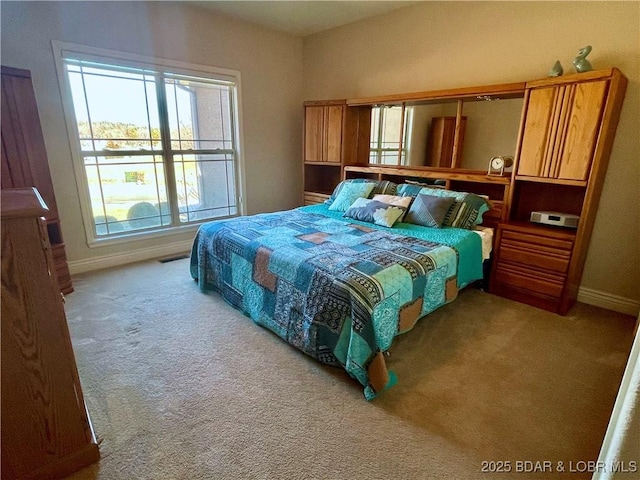 carpeted bedroom featuring visible vents and baseboards