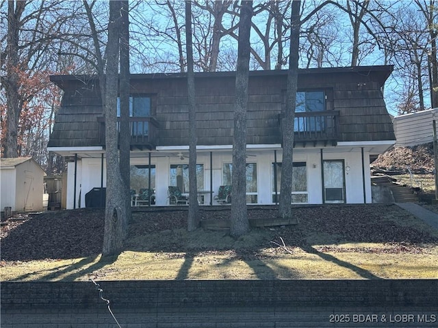 view of front of home featuring mansard roof and a balcony