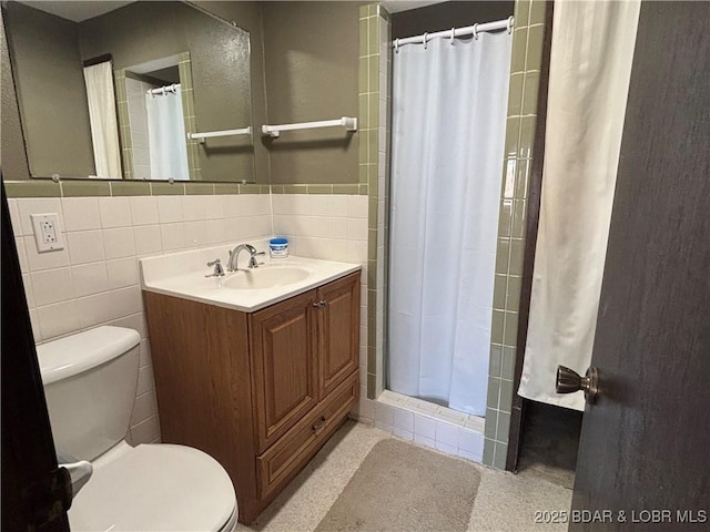 bathroom with toilet, curtained shower, tile walls, and vanity