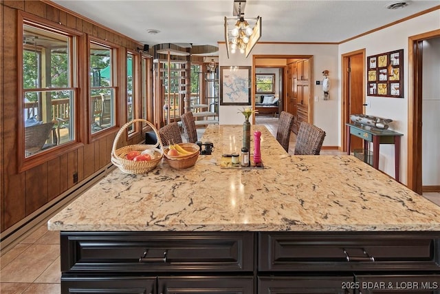 kitchen featuring ornamental molding, a healthy amount of sunlight, and light stone countertops