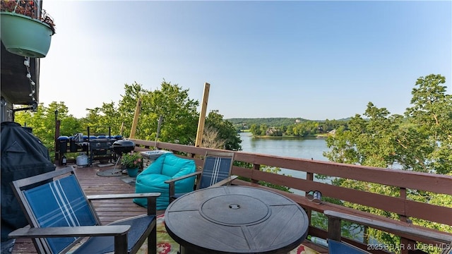 balcony with a deck with water view and an outdoor living space