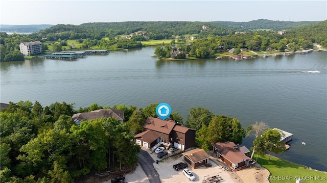 drone / aerial view featuring a forest view and a water view