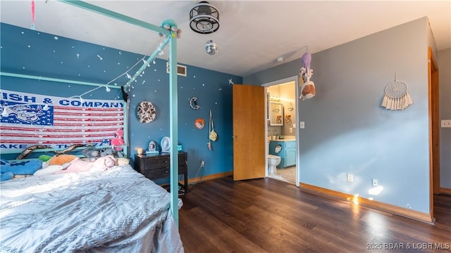 bedroom featuring ensuite bathroom, visible vents, baseboards, and wood finished floors