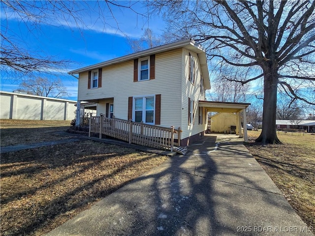 view of front of property with concrete driveway and a carport