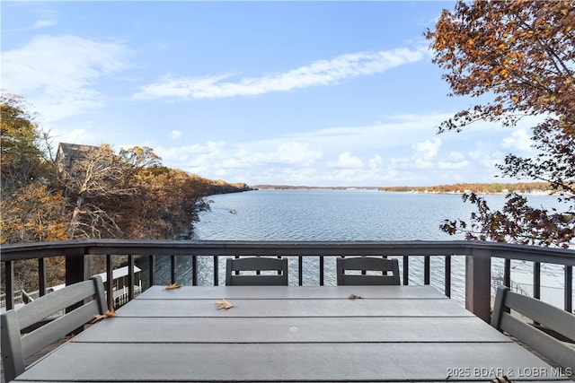 view of dock featuring outdoor dining area and a water view