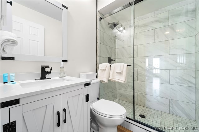 bathroom with a stall shower, vanity, and toilet