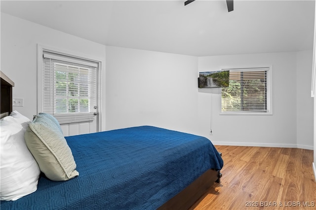 bedroom with a ceiling fan, baseboards, and wood finished floors