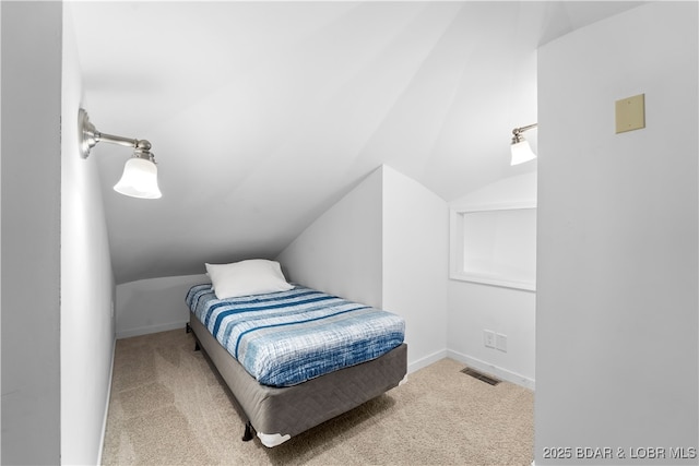 carpeted bedroom featuring lofted ceiling, visible vents, and baseboards