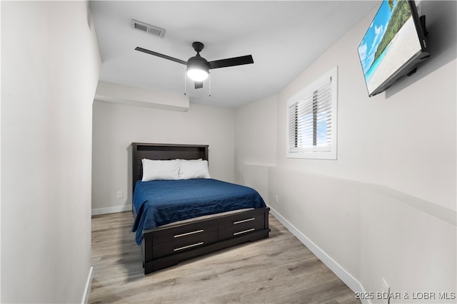bedroom with ceiling fan, wood finished floors, visible vents, and baseboards