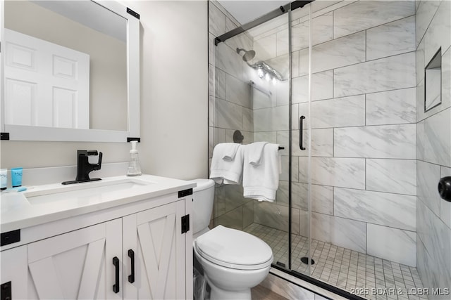 full bathroom with a stall shower, vanity, and toilet