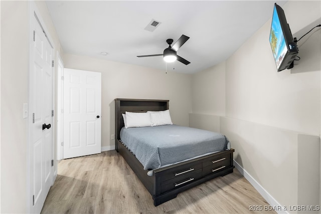 bedroom with light wood-style floors, visible vents, ceiling fan, and baseboards