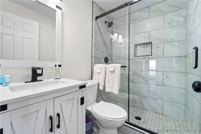 bathroom with toilet, a stall shower, and vanity