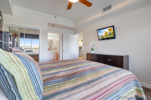 bedroom with carpet floors, connected bathroom, a ceiling fan, and baseboards