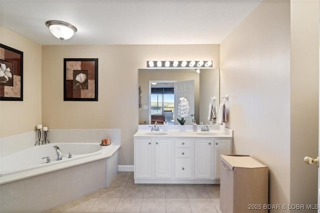 bathroom with a garden tub, double vanity, and tile patterned floors