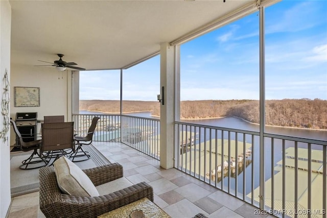 balcony with a water view and a ceiling fan