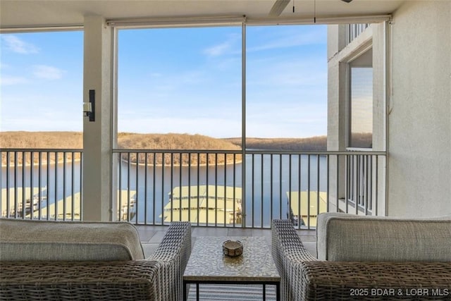 sunroom / solarium featuring a water view