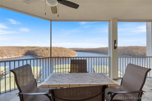 sunroom featuring a water view