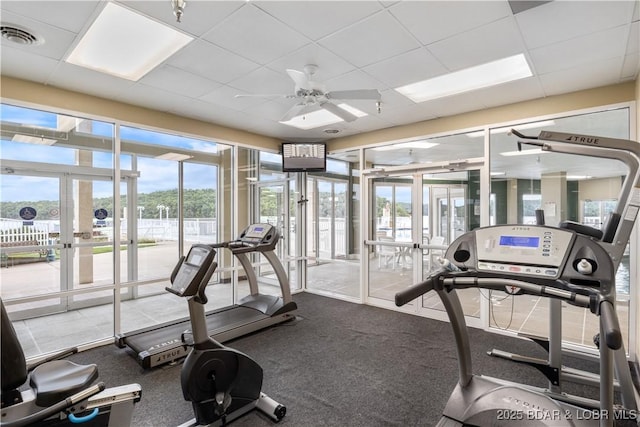 workout area featuring french doors, a drop ceiling, and a ceiling fan
