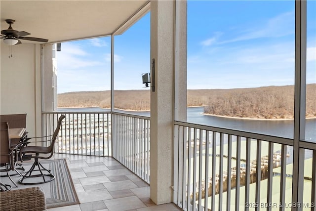 balcony featuring a water view and ceiling fan