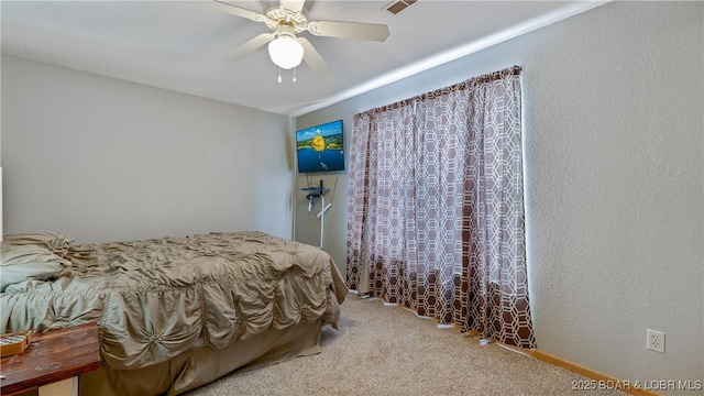 bedroom featuring ceiling fan, a textured wall, and carpet flooring