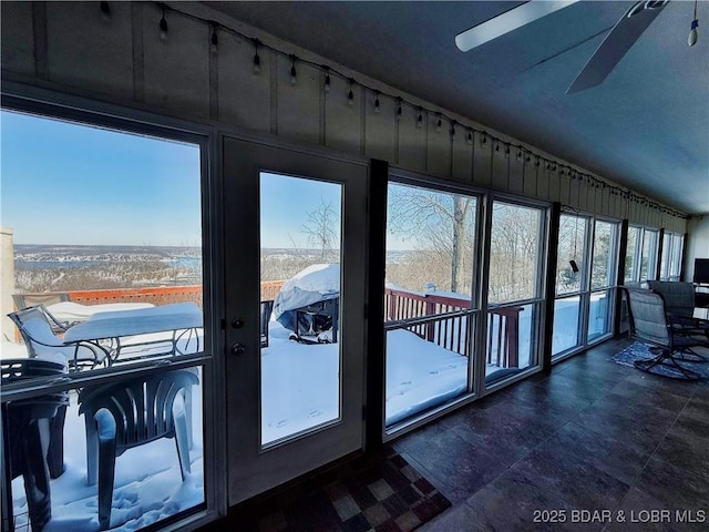 doorway to outside with lofted ceiling and ceiling fan