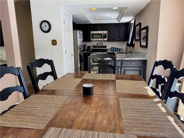 dining space with ornamental molding, a tray ceiling, and recessed lighting