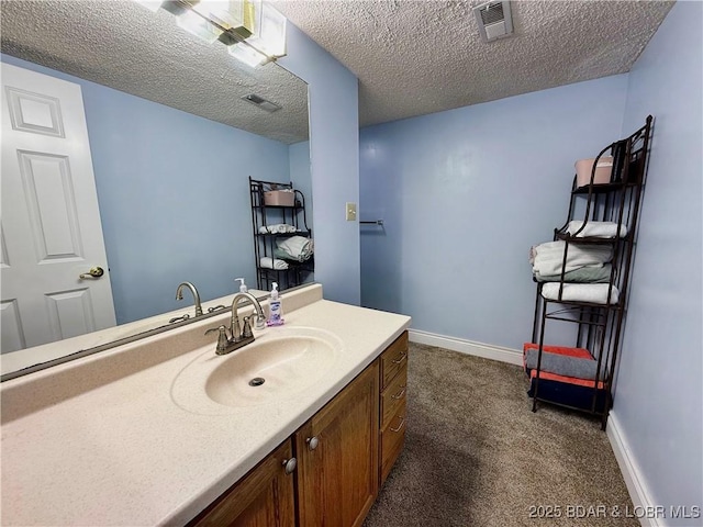 bathroom featuring visible vents, a textured ceiling, and vanity