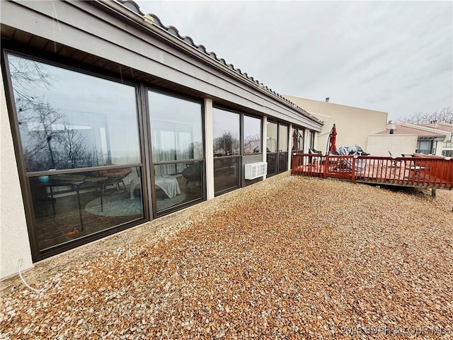 exterior space featuring a wooden deck and stucco siding