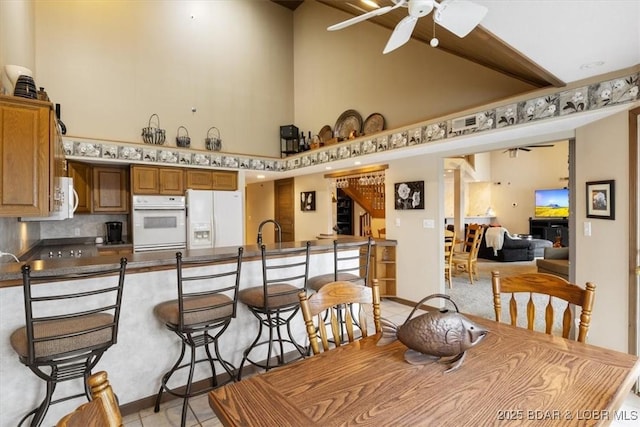 222 Park Place Ln Unit 4A, Kaiser, MO 65047 - dining space with a ceiling fan, high vaulted ceiling, and light tile patterned floors
