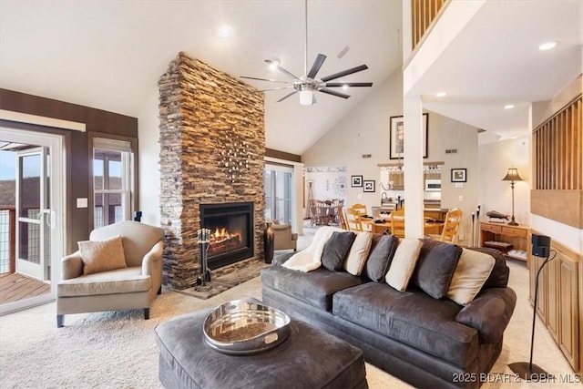 living area with a fireplace, recessed lighting, light colored carpet, ceiling fan, and high vaulted ceiling